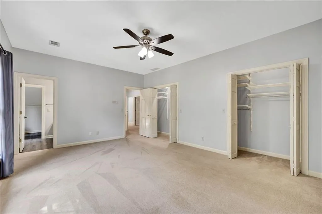 Unfurnished bedroom featuring ceiling fan and light colored carpet