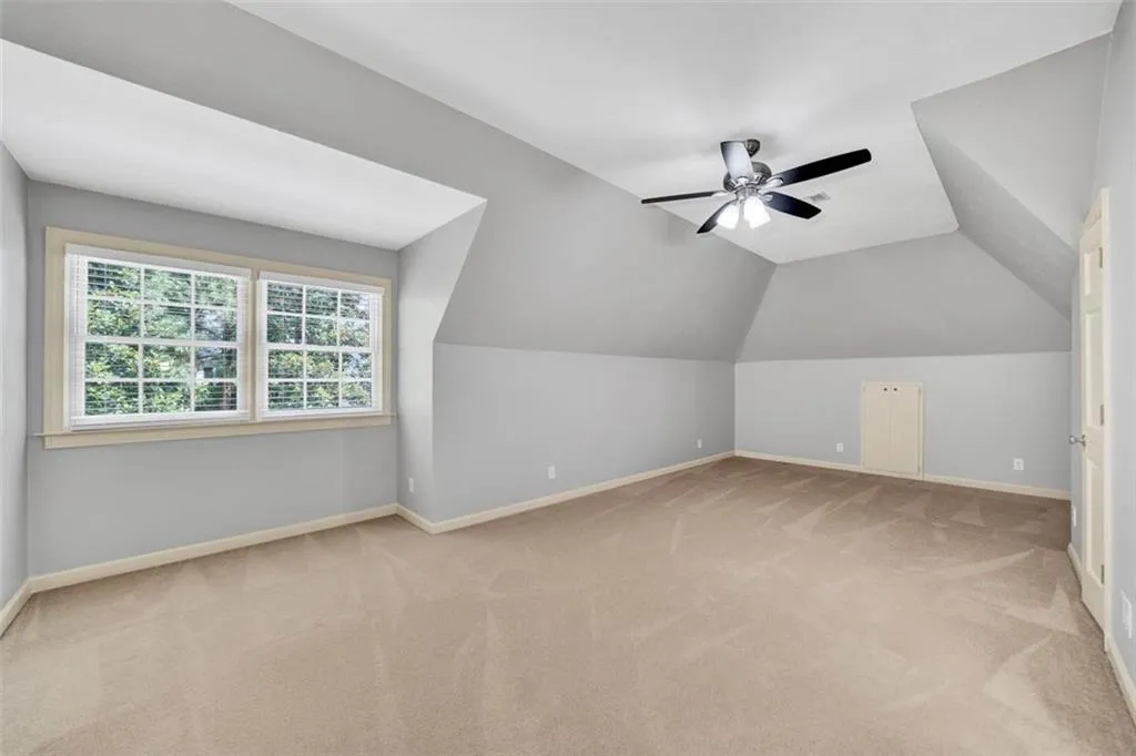 Bonus room featuring ceiling fan, carpet floors, and lofted ceiling