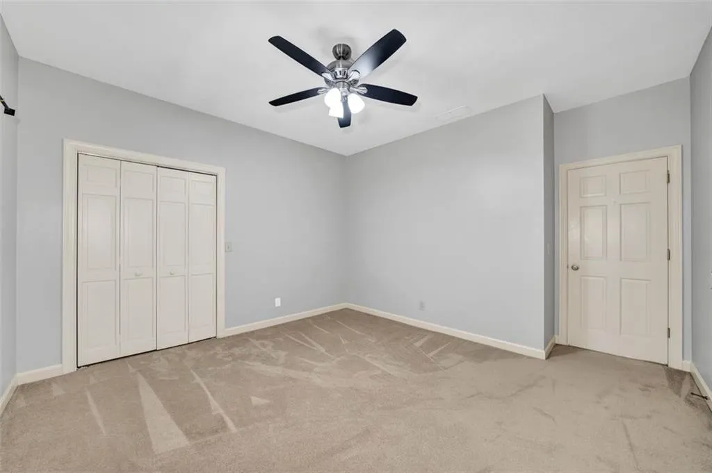 Unfurnished bedroom with light carpet, a closet, and ceiling fan