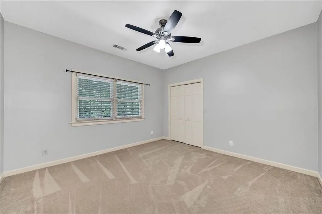 Carpeted spare room featuring ceiling fan
