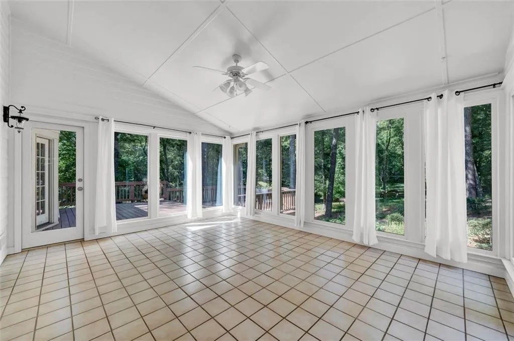 Unfurnished sunroom featuring ceiling fan and lofted ceiling