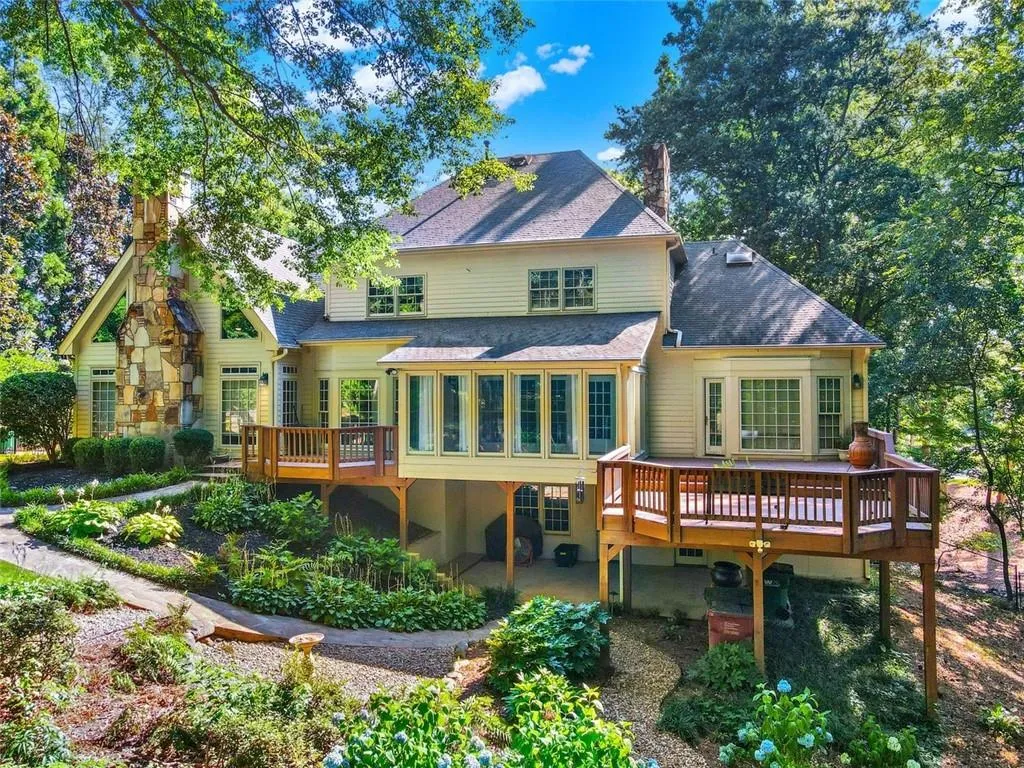 Rear view of property featuring a sunroom and a deck