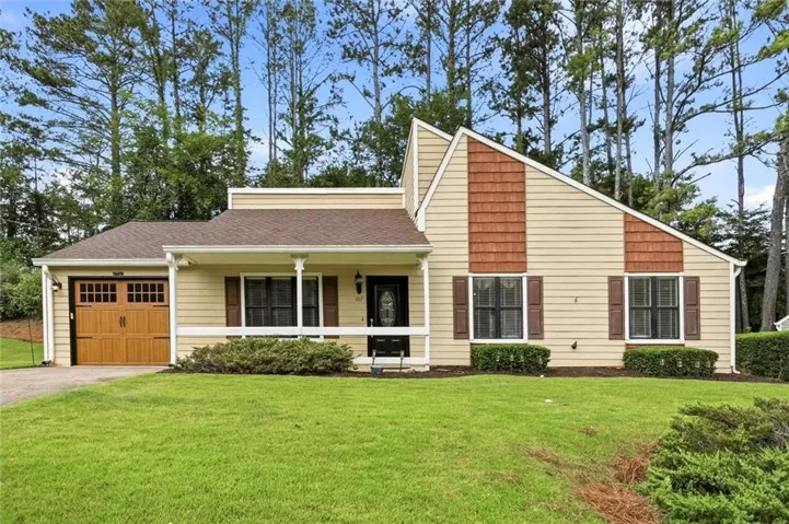 Welcome to 107 Riverchase Dr  featuring light-toned siding with contrasting shingle accents and a covered front porch, Bonus new Pella Garage door with whisper quite automatic opener