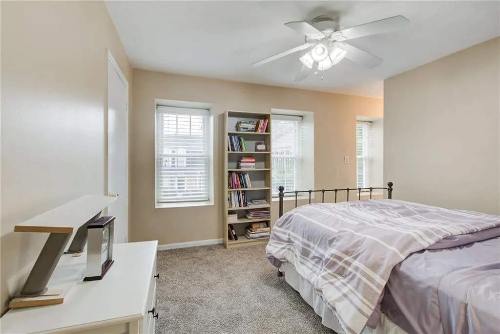 Bedroom with light colored carpet and ceiling fan