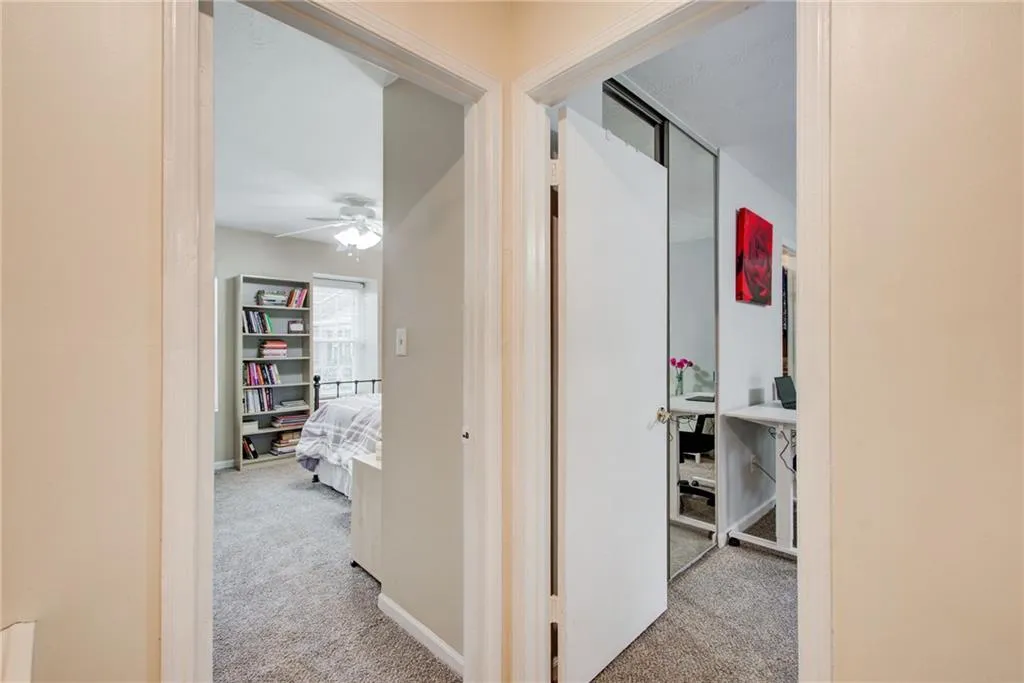 Hallway featuring light carpet