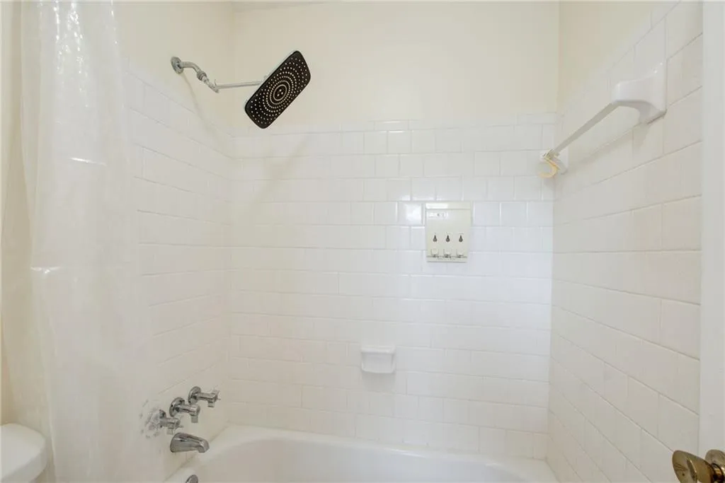 Bathroom featuring shower / tub combo with curtain and toilet