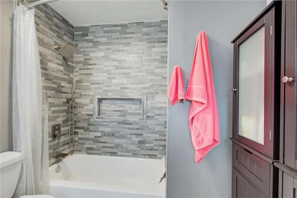Bathroom with shower / tub combo and toilet
