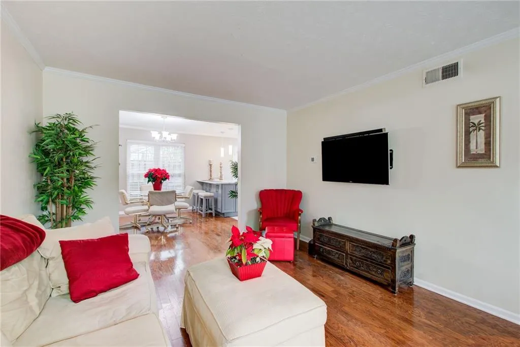 Living room with wood finished floors,view to dining and kit  molding,