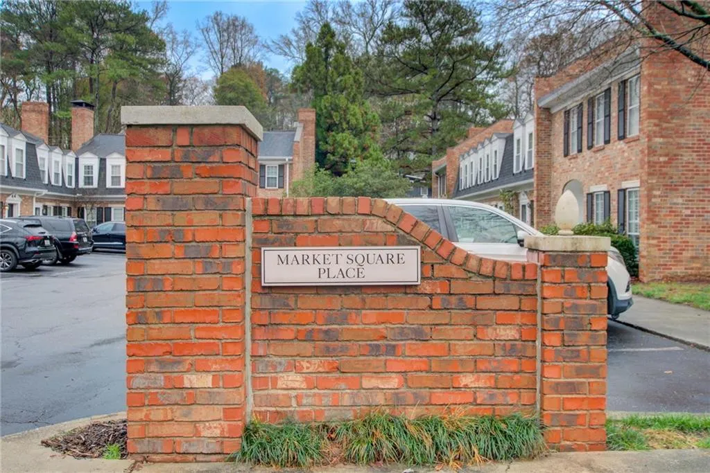 Community / neighborhood sign with a residential view and uncovered parking