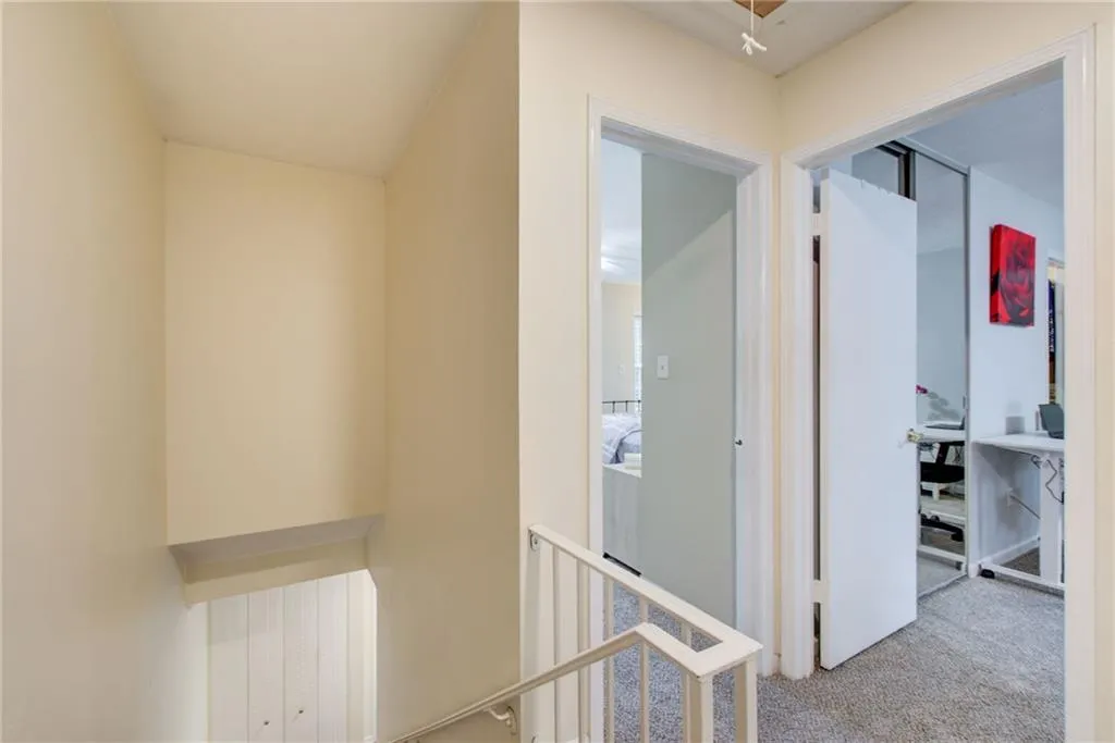 Hallway with an upstairs landing and carpet