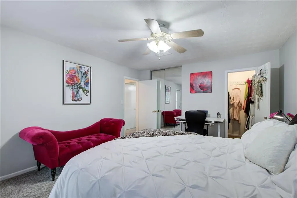 Bedroom with a closet, carpet flooring, a ceiling fan, and a desk