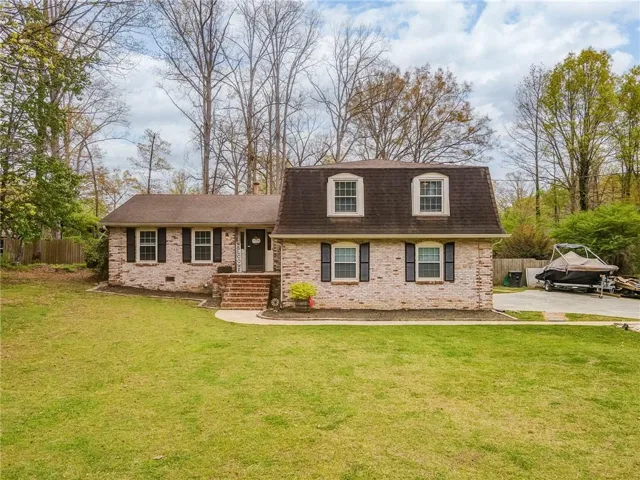 View of front of property featuring roof with shingles, brick siding, and crawl space