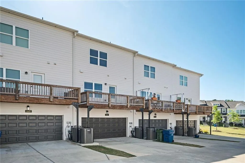Rear view of property featuring driveway, an attached garage, and a residential view