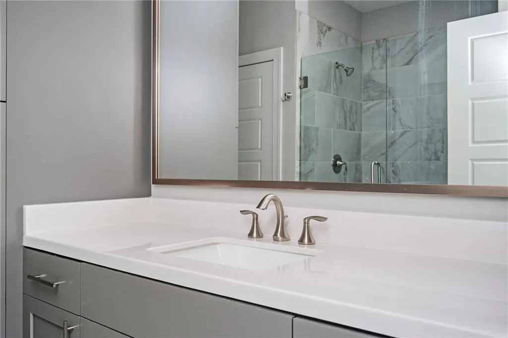 Full bathroom with a marble finish shower and vanity