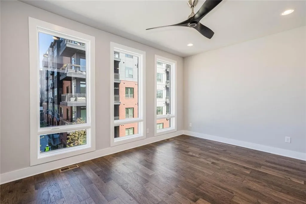 Unfurnished room featuring dark wood-type flooring and ceiling fan