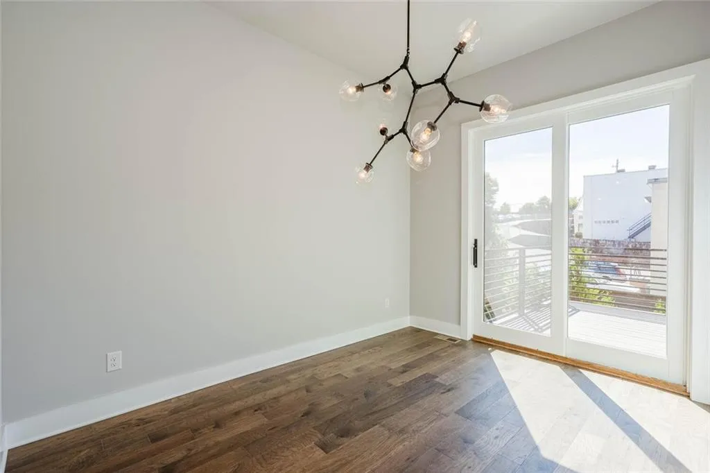 Empty room with an inviting chandelier and dark hardwood / wood-style floors