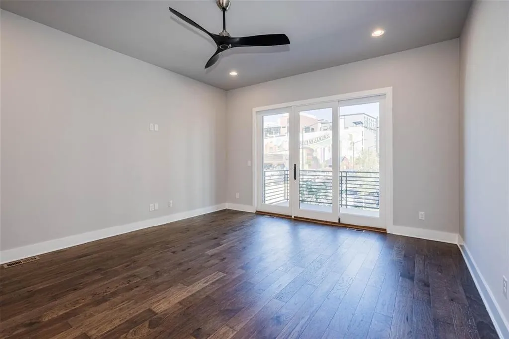 Empty room featuring sink, dark wood-type flooring, and ceiling fan