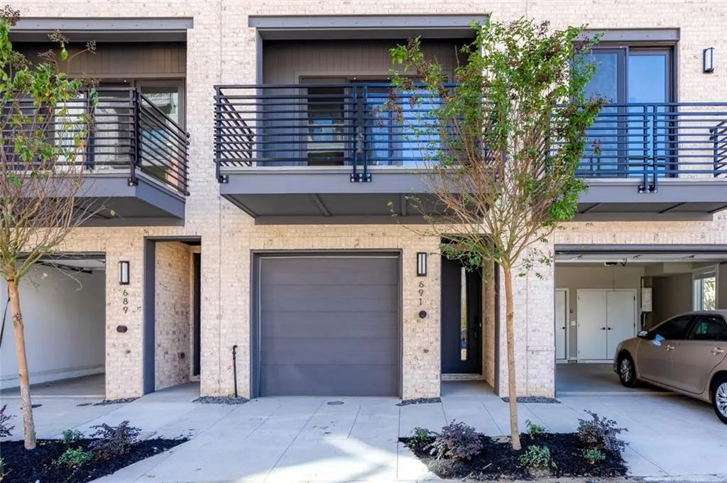 View of property featuring a garage and a balcony