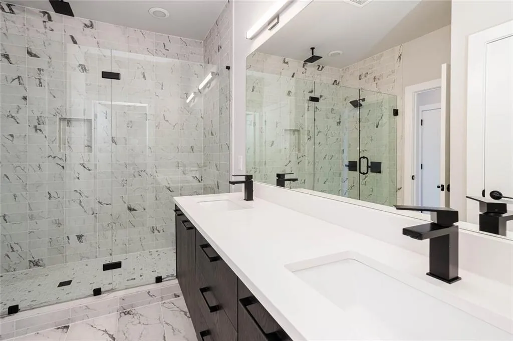 Bathroom with double sink vanity, tile flooring, and walk in shower