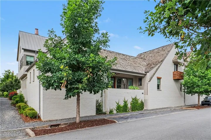Exterior featuring painted brick, a metal roof, and a wood shake shingle roof