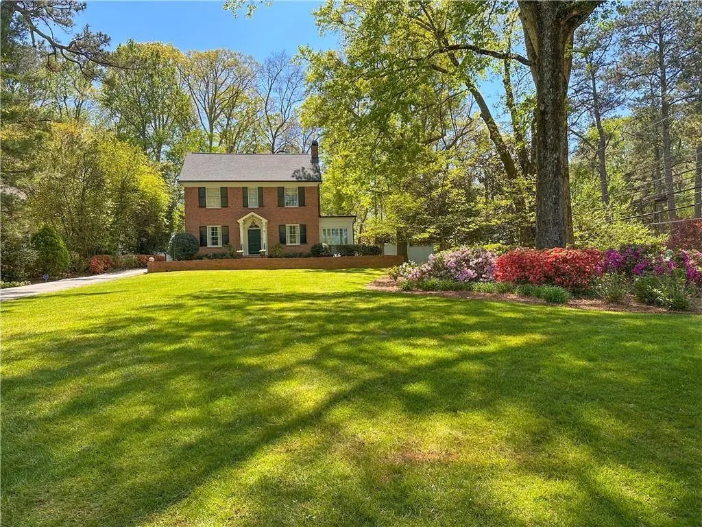 View of front of property with a front yard and brick siding