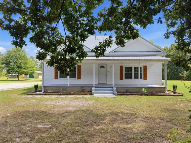 White siding exterior with a metal roof