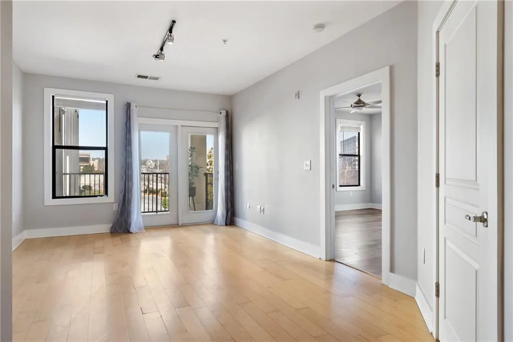Unfurnished room featuring light wood-style floors, visible vents, baseboards, and track lighting