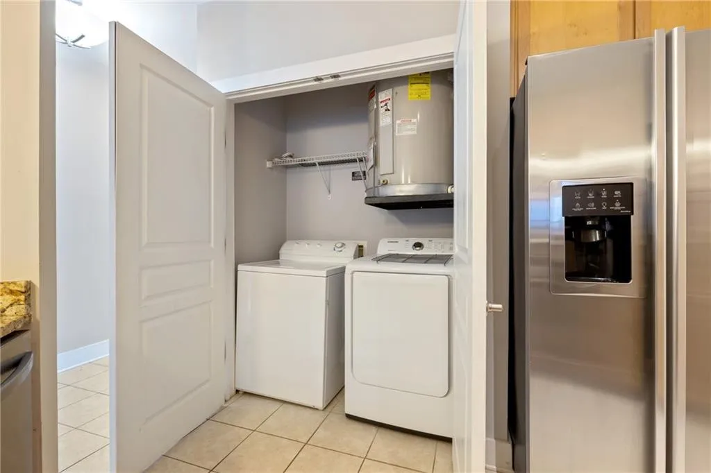Laundry area with laundry area, light tile patterned floors, and washer and dryer