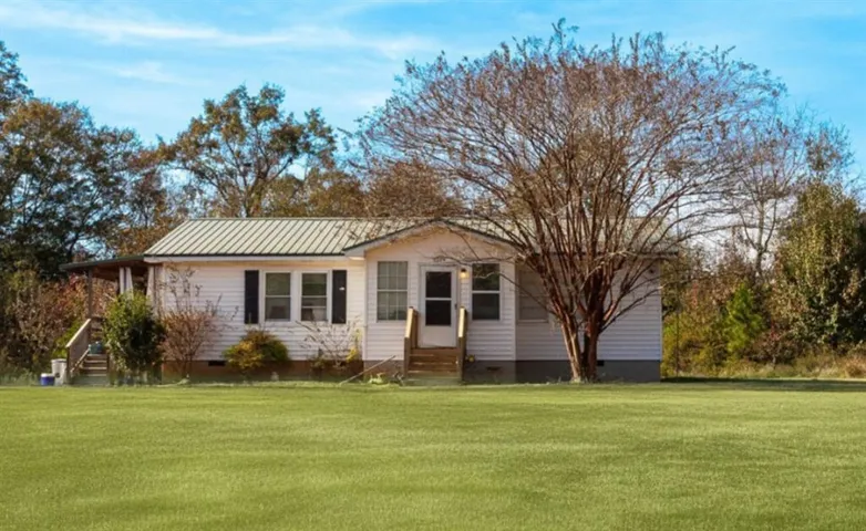 View of front of property with crawl space, a front lawn, entry steps, and a metal roof
