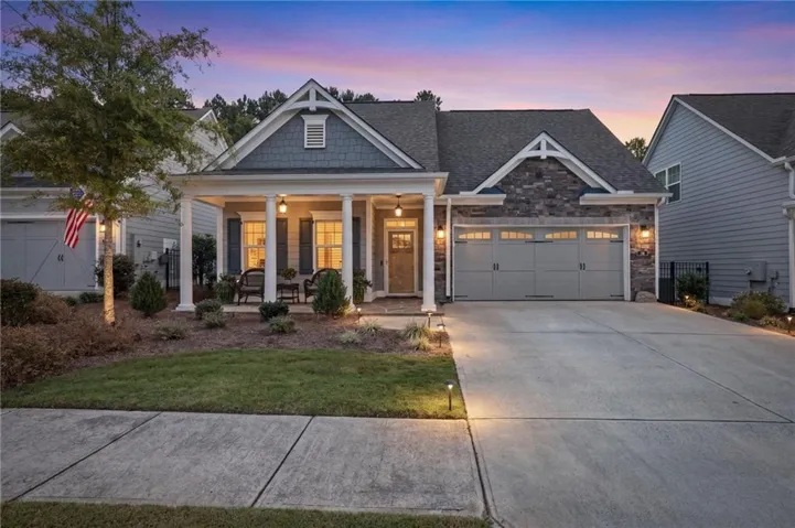 Stone and siding exterior with a covered front porch featuring square columns