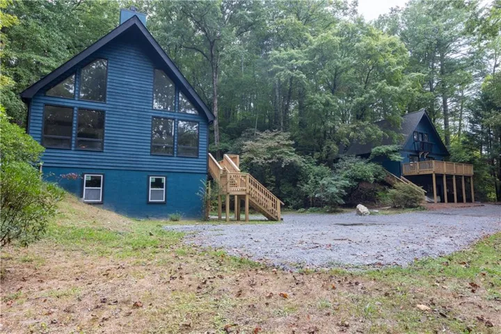 View of side of home with stairway and a wooden deck