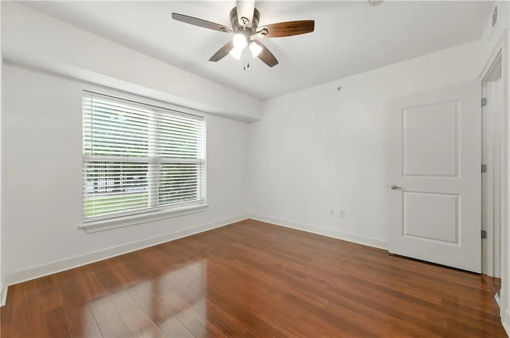 Spare room with ceiling fan and dark wood-style floors