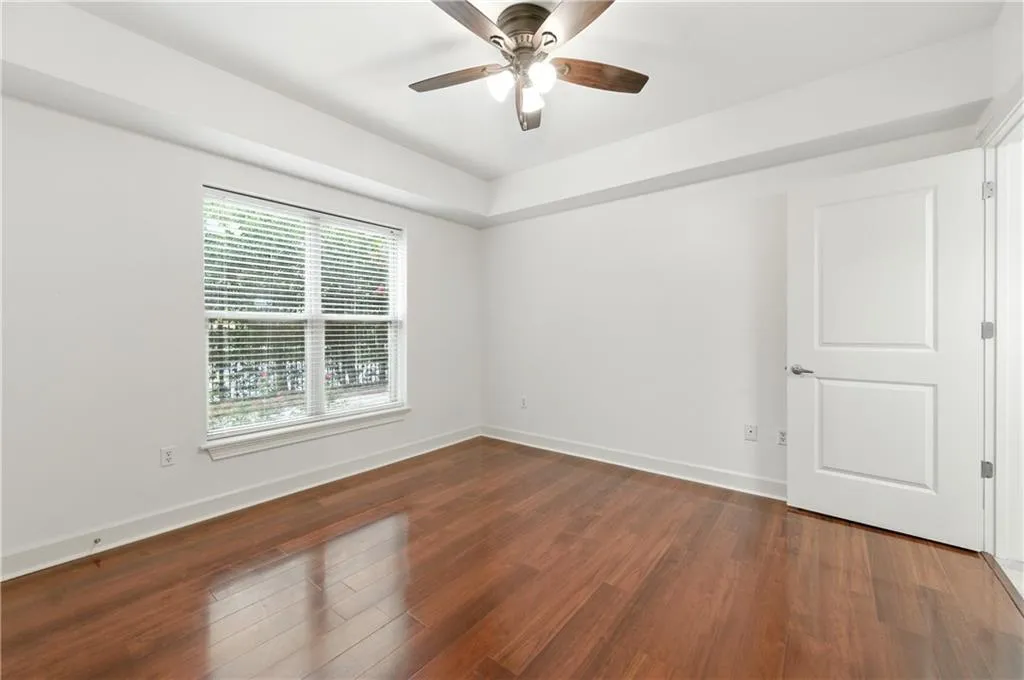 Spare room featuring dark wood-style floors and ceiling fan