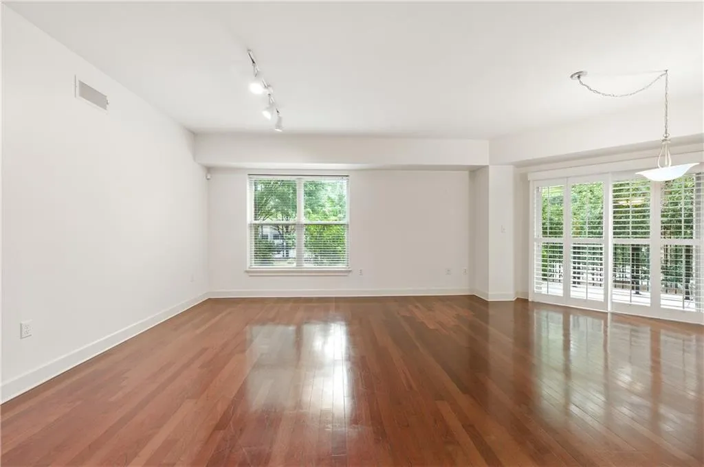 Unfurnished room with hardwood / wood-style floors and rail lighting