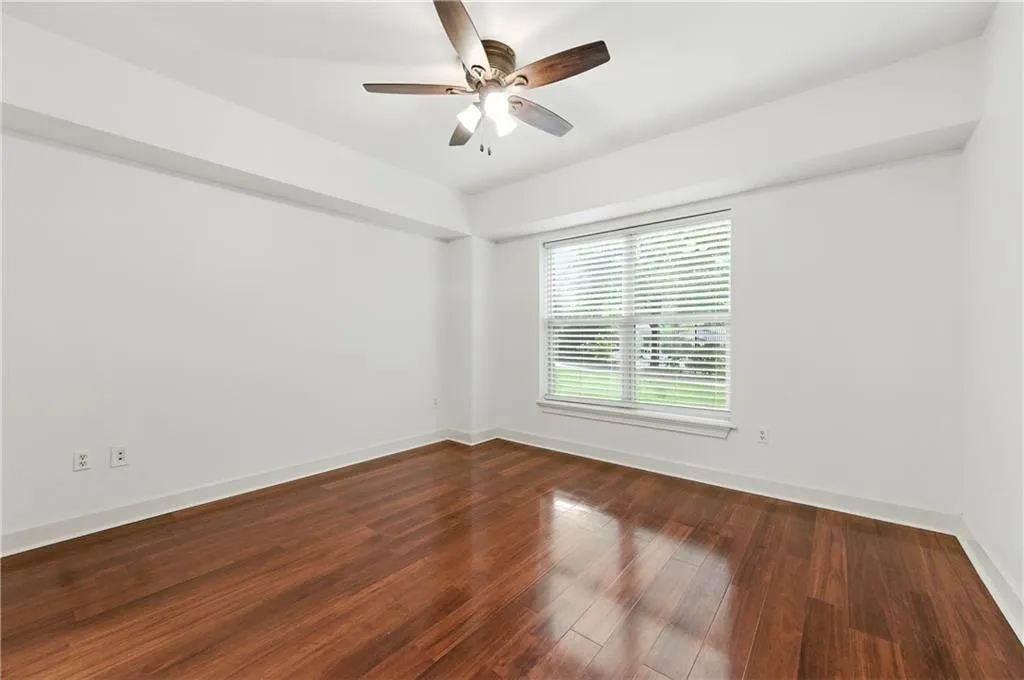 Spare room with dark wood-style floors and a ceiling fan