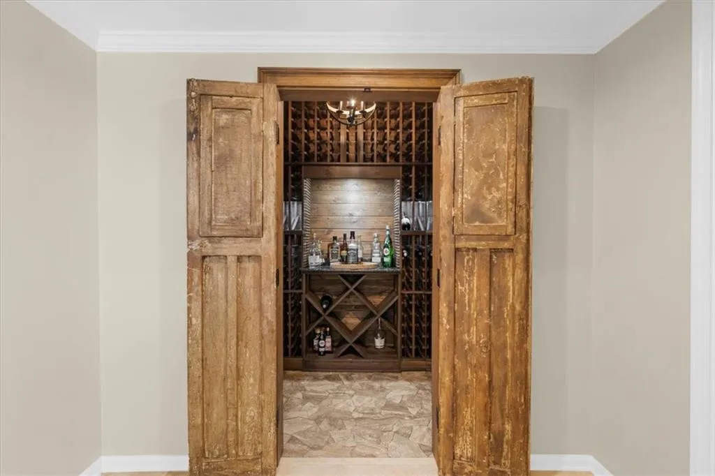 Wine room with crown molding and a chandelier