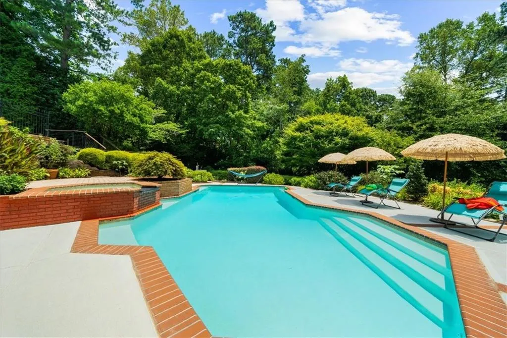 Swimming pool with a jacuzzi and a patio area