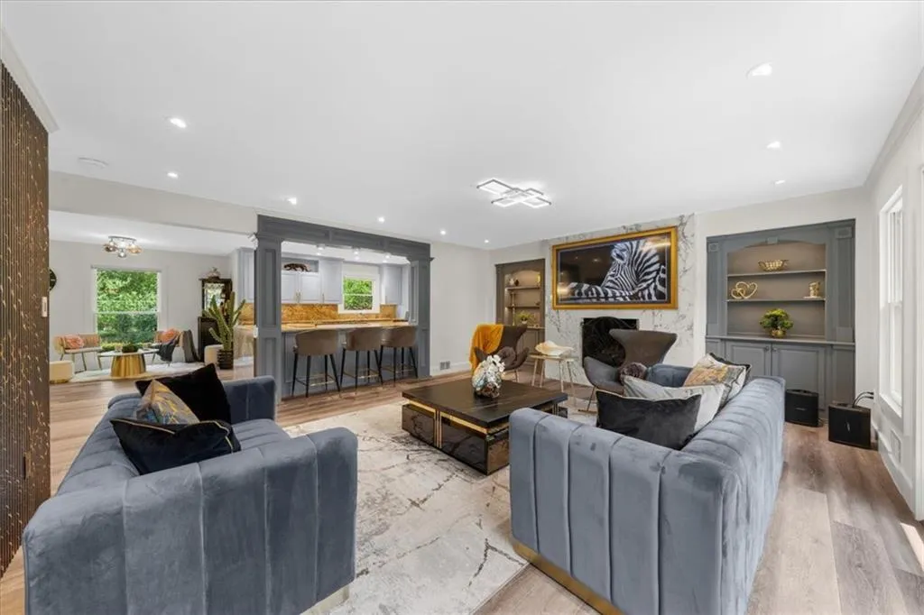 Living area featuring light wood-style flooring, built in features, decorative columns, and recessed lighting