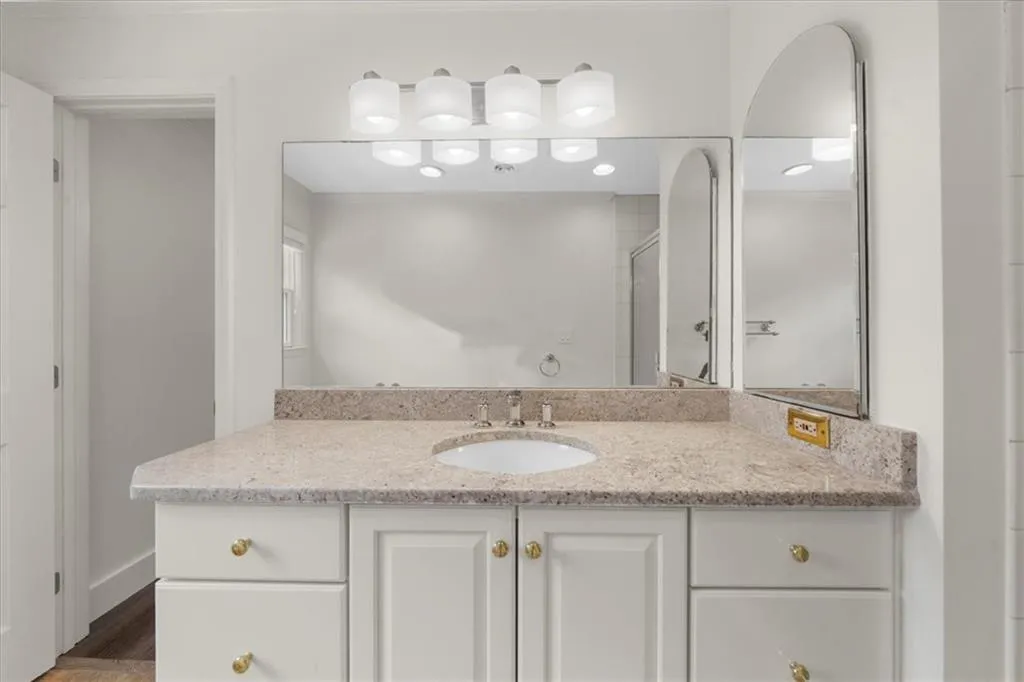 Bathroom featuring vanity, an enclosed shower, and wood finished floors