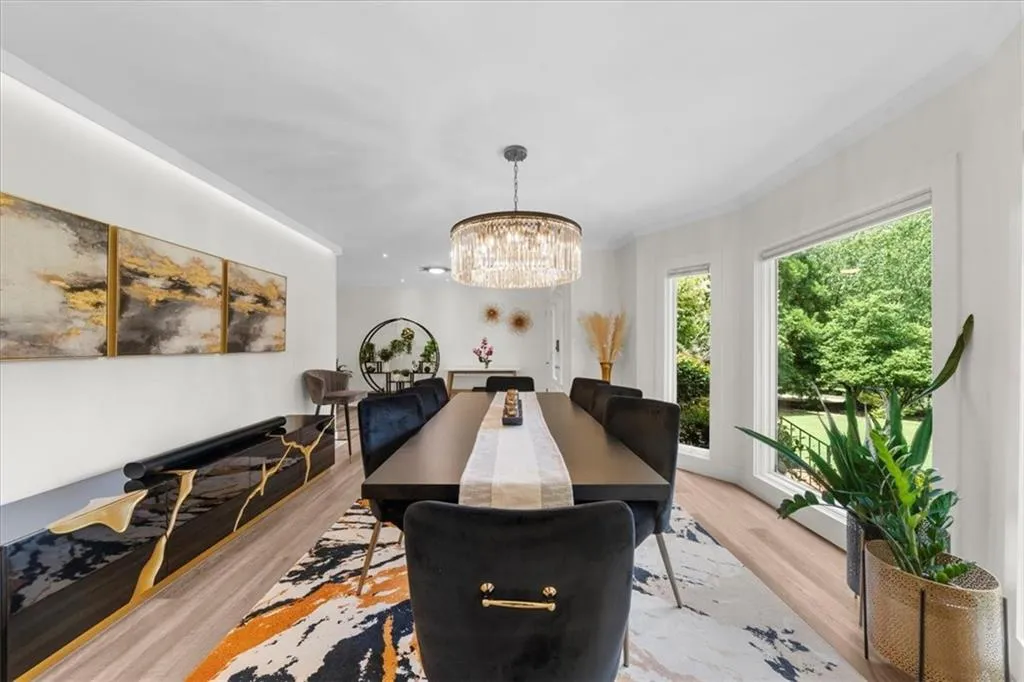 Dining space with light wood finished floors, a chandelier, and crown molding