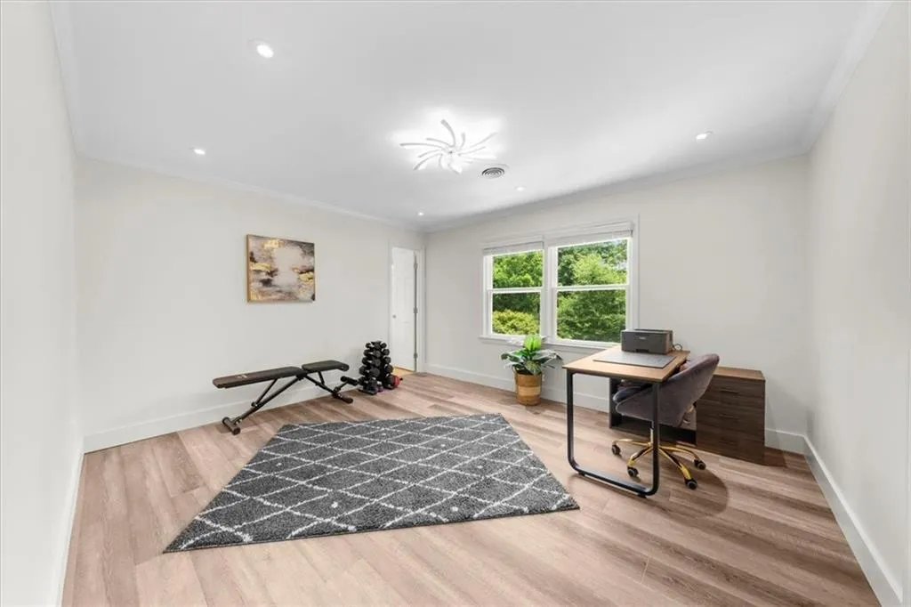 Office space with ornamental molding, wood finished floors, and recessed lighting