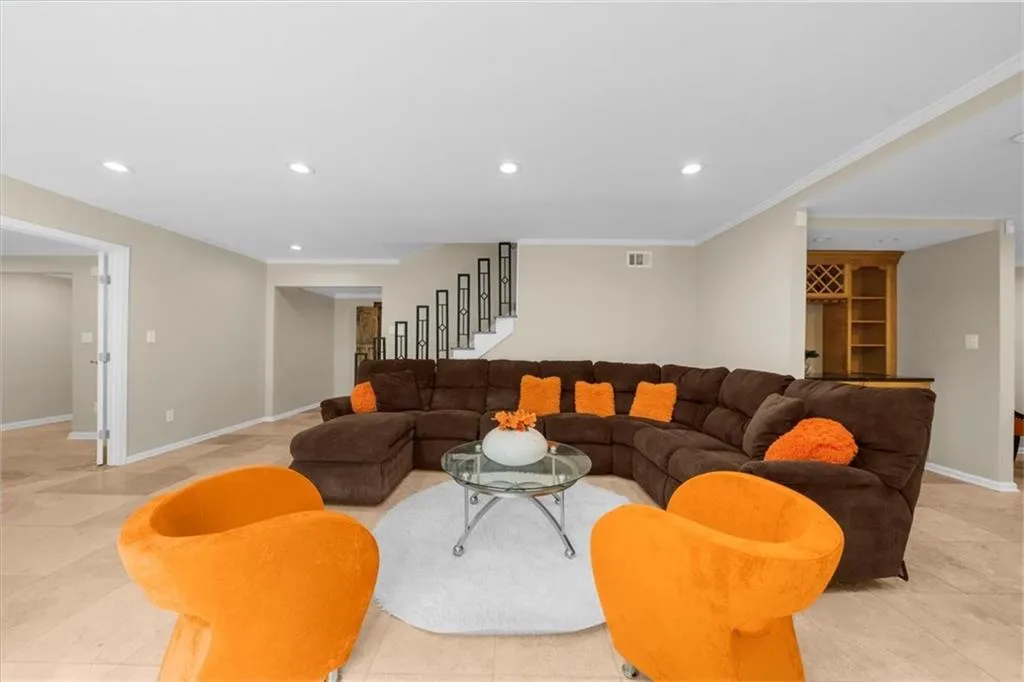 Living area featuring recessed lighting, stairs, crown molding, and light tile patterned floors