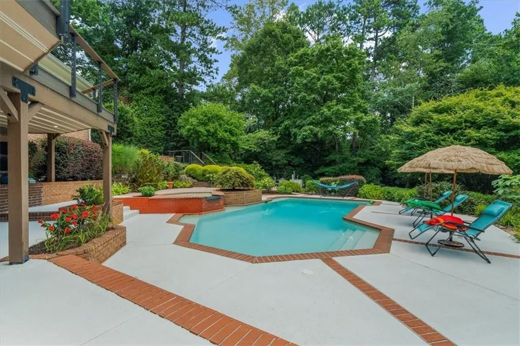 Outdoor pool featuring a patio and view of scattered trees
