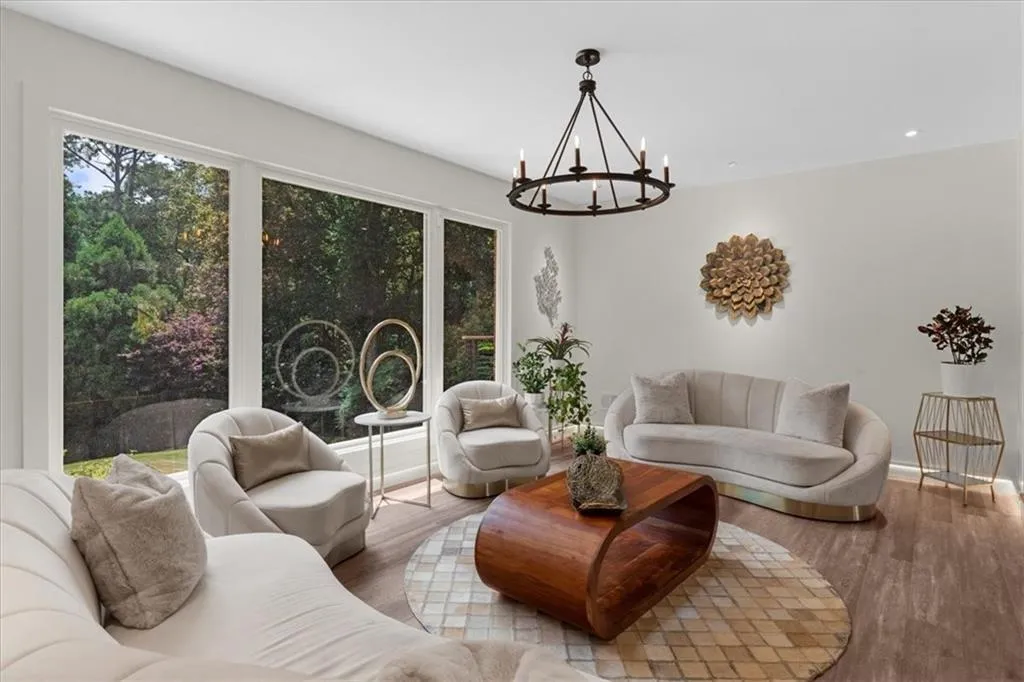 Living room with a chandelier, plenty of natural light, wood finished floors, and recessed lighting