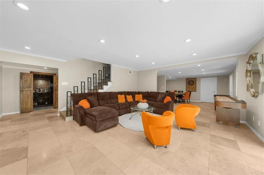 Living area featuring crown molding, stairway, recessed lighting, light tile patterned floors, and a bar
