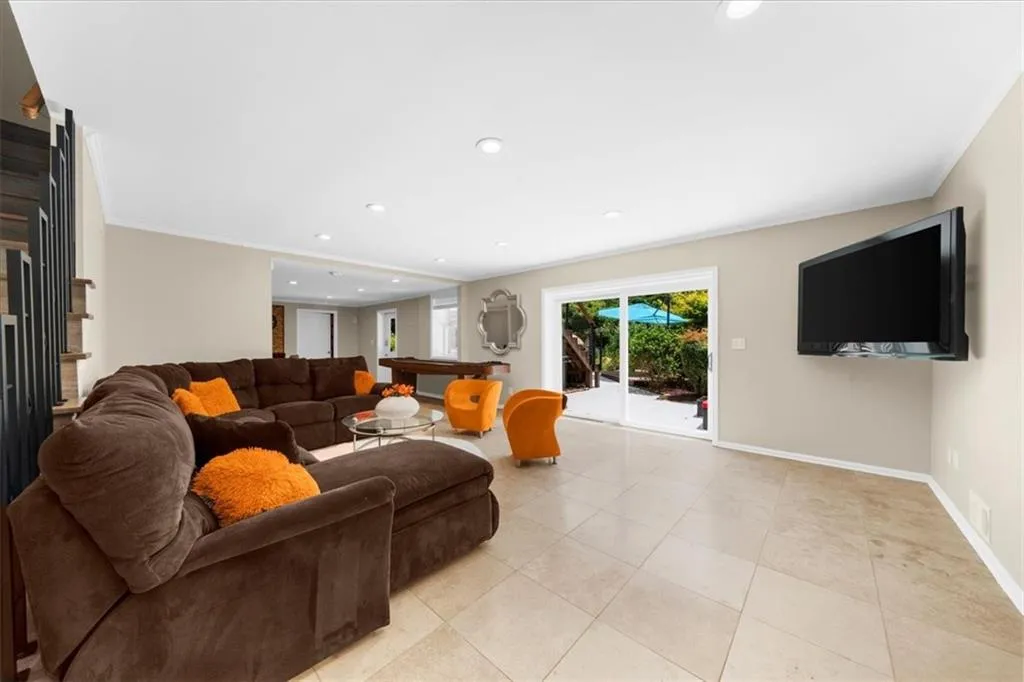 Living room with crown molding, recessed lighting, stairs, light tile patterned flooring, and billiards table