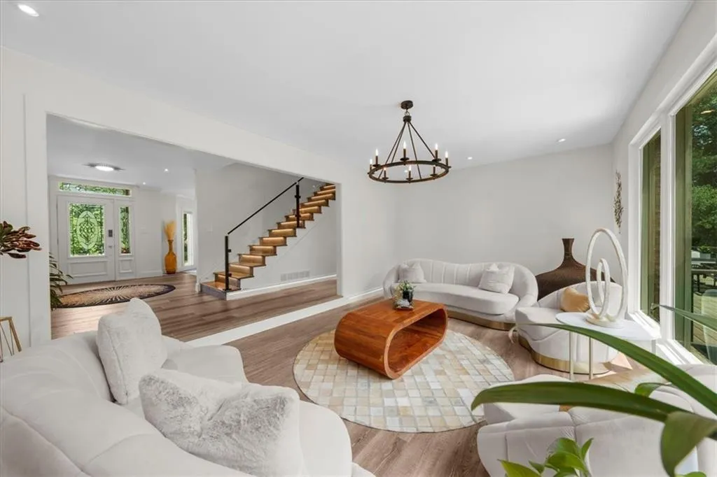Living room featuring wood finished floors, stairway, recessed lighting, and a chandelier