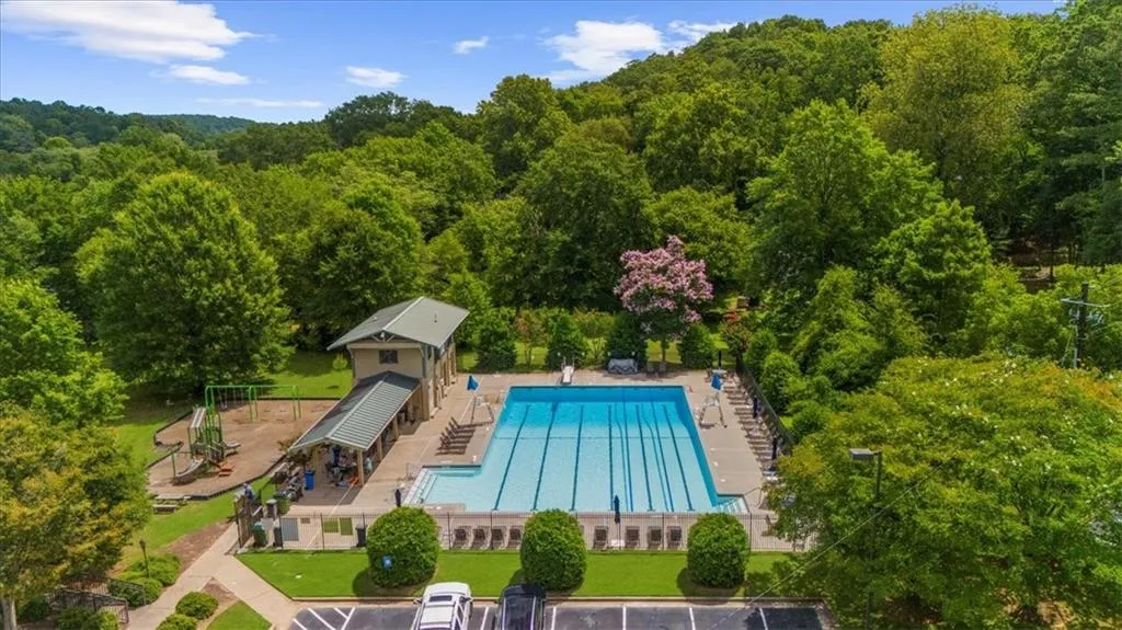 Community pool with a forest view and a patio