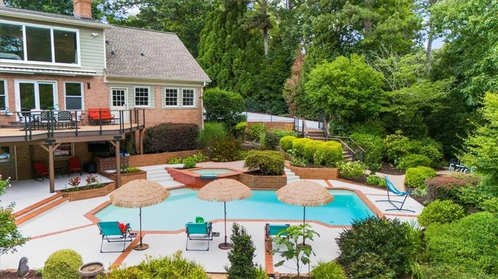 Outdoor pool featuring an in-ground hot tub, stairs, a patio area, and a deck