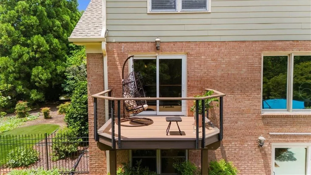 View of side of home featuring a wooden deck and brick siding